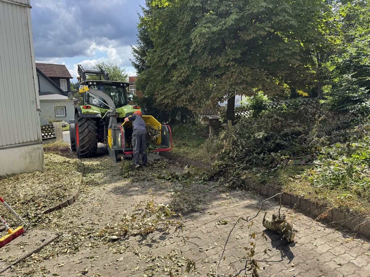 Traktor mit Häcksler im Einsatz, Hackschnitzel auf der Fläche